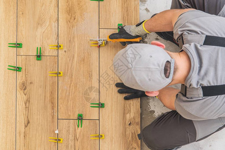 专业的改造工人在厨房区域安装像陶瓷一样的木地板图片