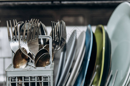 打开洗碗机关闭被干净的洗过的盘子堵塞干餐具特写勺子叉杯子图片