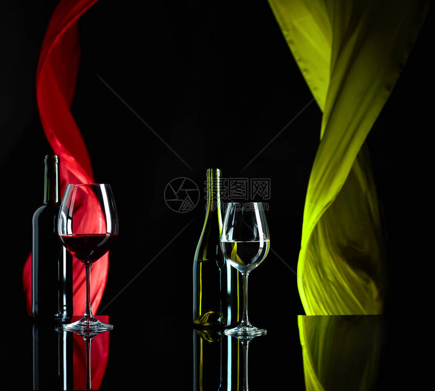 黑色反射背景的红酒和白葡萄酒日落幕在风中挥舞图片