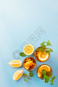 传统冰茶加柠檬薄荷和高杯冰蓝背景图片