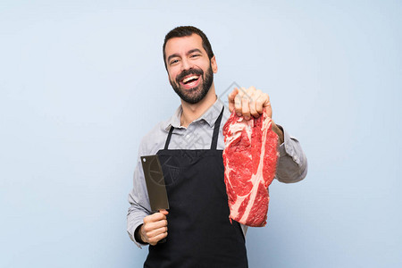 拿着生肉的愉快的厨师背景图片