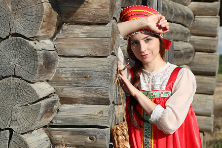 身着传统服饰木墙的女孩图片