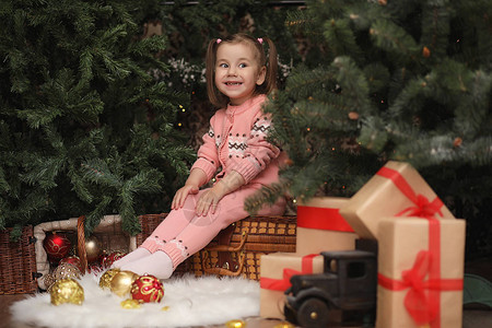 圣诞气氛中的小女孩这个女孩对圣诞节和礼物很满意树上的一个图片