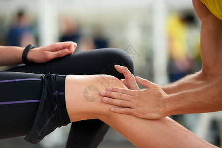 女人锻炼后感觉膝盖疼痛年轻女子在体育俱乐部锻炼时膝盖受伤图片