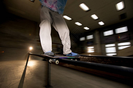 在滑板公园做滑冰特技飞行的无法辨认的年轻人的低剖面动作镜头图片