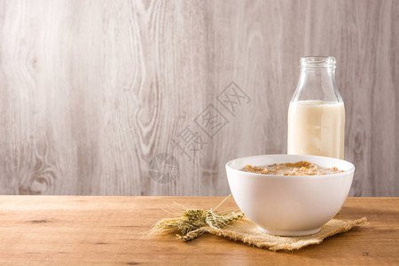 木桌上的燕麦牛奶和谷物复制空间图片