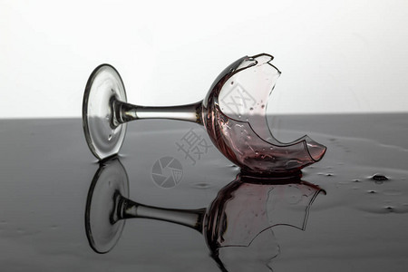 含红葡萄酒的破碎葡萄酒杯它图片