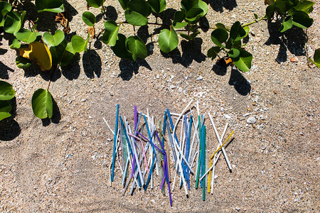 沙滩上收集的沙土背景不同多色塑料稻草堆积物图片