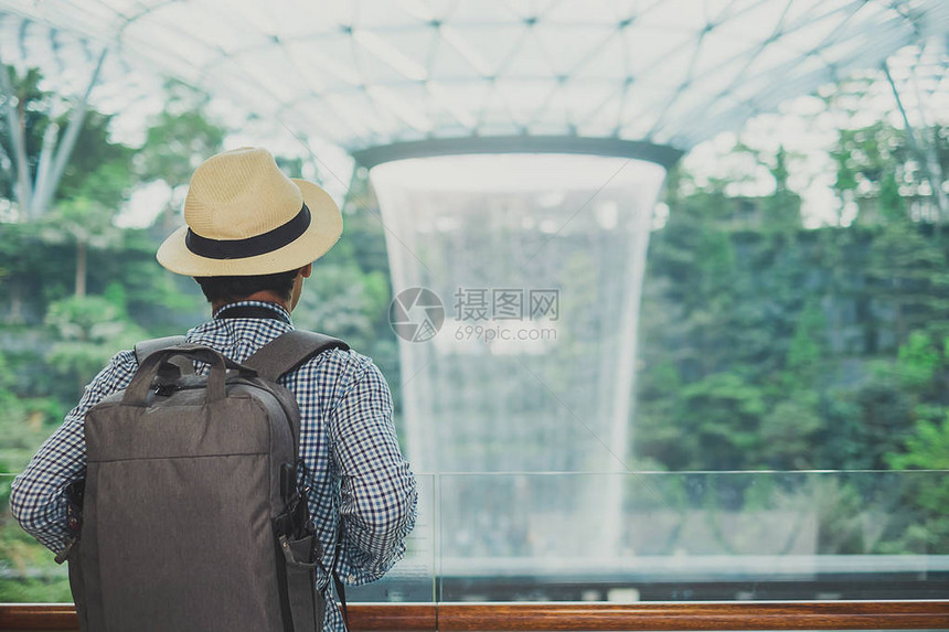 亚洲旅行者站着寻找朱厄尔尚吉机场美丽的雨旋图片