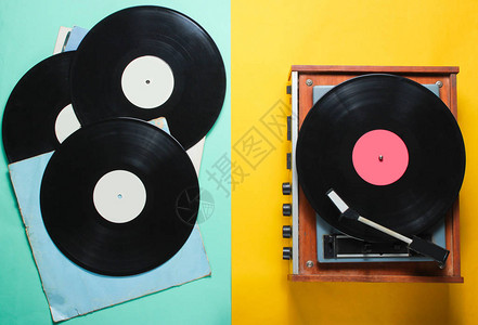 复古风格的黑胶唱片播放器和黑胶唱片与彩色纸背景上的封面图片