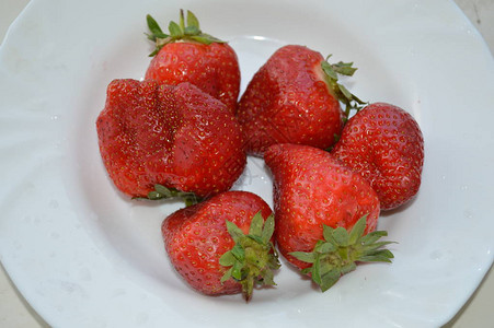 盘子上的大号春草莓背景图片