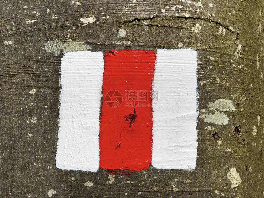 在标志徒步路线或瑞士山路标志的岩石上涂有红图片