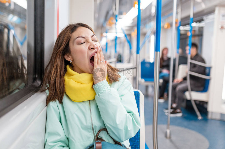 失眠女孩在下班回家后在地铁里睡觉或午睡图片