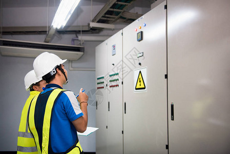 电气工程师在控制室和记录生产过程中工厂的电力运行情况图片