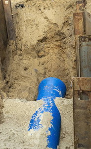 挖沟壕坑的水管在道修理期间用一个水管图片