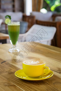 一杯咖啡和绿色脱毒饮料放在餐图片
