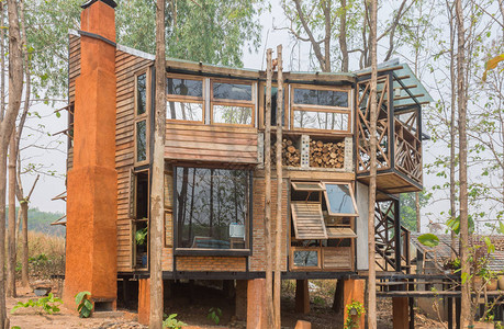 乡村风格缩放视图中的木材和混凝土外观房屋设计天然林间的外屋小山上的图片