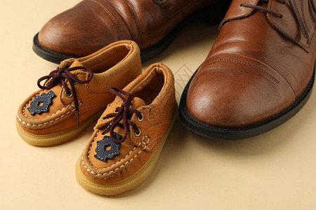 颜色背景上的棕色皮鞋和童鞋文图片