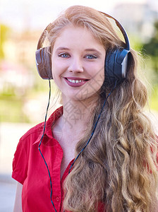 女孩戴耳机和穿红衬衫听音乐图片