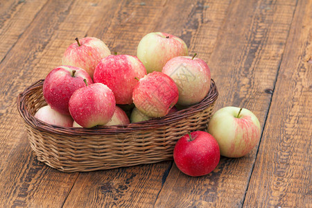 红成熟的苹果放在老木板上的篮子图片