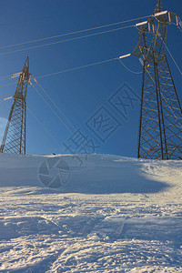 雪中电力晴天雪山顶电力缆塔冬季发展生态理念图片