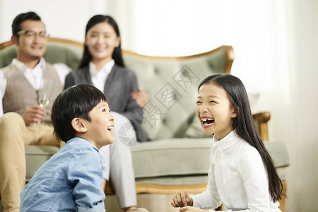 有两个孩子的亚洲家庭在家玩得图片