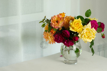 美丽的夏日花束橙黄色和紫色的英国玫瑰在玻璃花瓶里图片