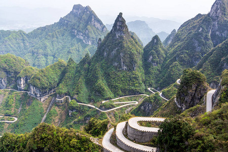 天门山有尖悬崖和绿色试探的通向道路高清图片