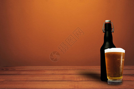 一杯红木桌上的啤酒和黑瓶啤酒美丽的橙色墙壁图片