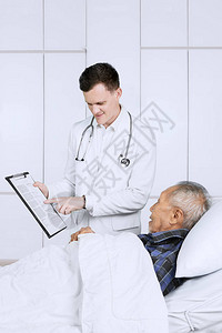 白种男医生向老年病人出示剪贴板图片
