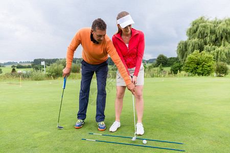 年轻女高尔夫球手与一名高尔夫图片