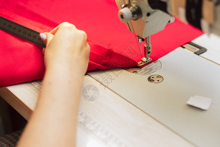 裁缝用尺子测量织物女人在一家服装厂工作裁缝用纫机在钩图片