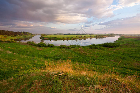 俄罗斯日落时绿河岸的夏季风图片
