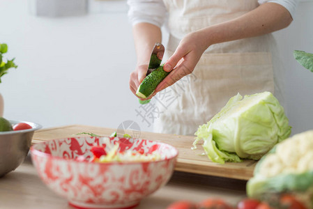 用新鲜蔬菜做沙拉女人在砧板上切蔬菜图片