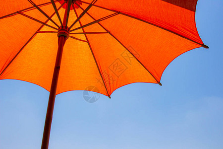 橙色海滩伞由木制的木制用于保护阳光图片