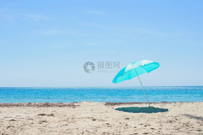 蓝太阳伞在沙滩上对着蓝色的海西班牙的科斯塔图片