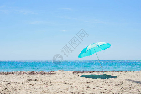 蓝太阳伞在沙滩上对着蓝色的海西班牙的科斯塔图片