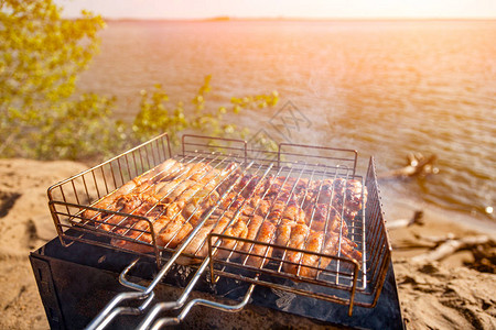 烤架上的鸡肉以大海和滩古食物摄影为背景图片