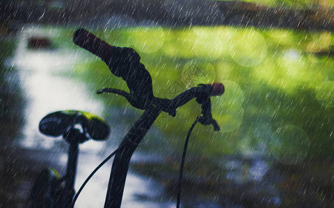 月光脚踏车在雨下背景中带有boke图片