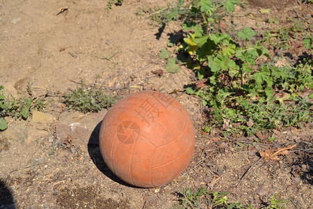 孩子们在童年时踢足球的旧橙色球图片
