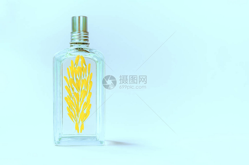 蓝色底的透明香水瓶装有黄色花图片
