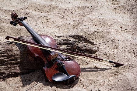 木小提琴头弓在海滩的木板旁边在沙滩图片