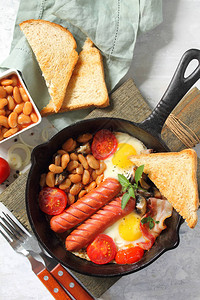 早餐用英语炒鸡蛋配培根豆子蘑菇香肠和西红柿图片