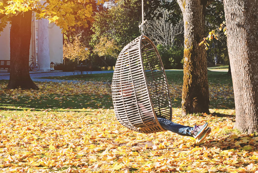 秋天公园千年女孩在落叶时在户外摇晃着挂着长成图片