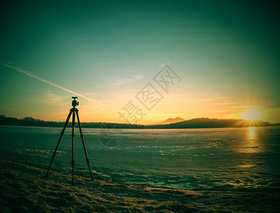 摄影师三脚架准备拍摄冬季寒冷河图片