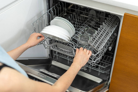 妇女打开现代洗碗机的高角度视野背景图片