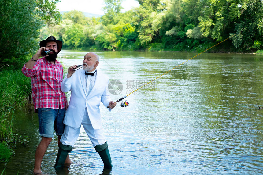 父亲和儿子一起放松垂钓者男人钓鱼快乐的祖父和孙子在河泊位上拿着钓鱼竿快乐的父子拿着鱼图片