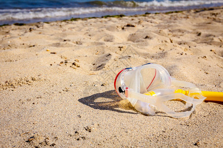 潜水面罩和呼吸管呼吸管都放在沙滩上图片