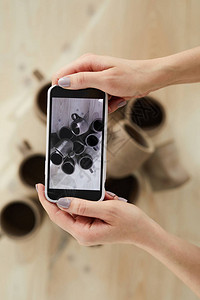 关闭女工匠在复制空间陶瓷车间拍摄手制陶瓷制品智能手机图片