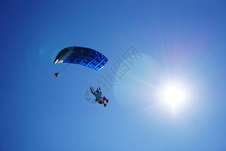 跳伞者在降落伞的蓝色小天篷下图片